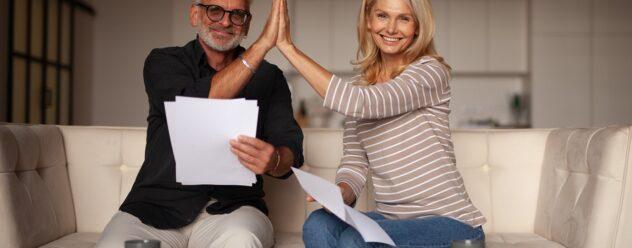 Couple de plus de 50 ans signant un contrat immobilier