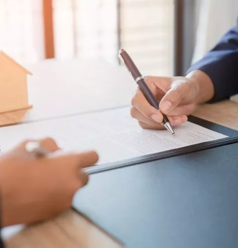 Deux personnes signant un contrat de vente immobilière